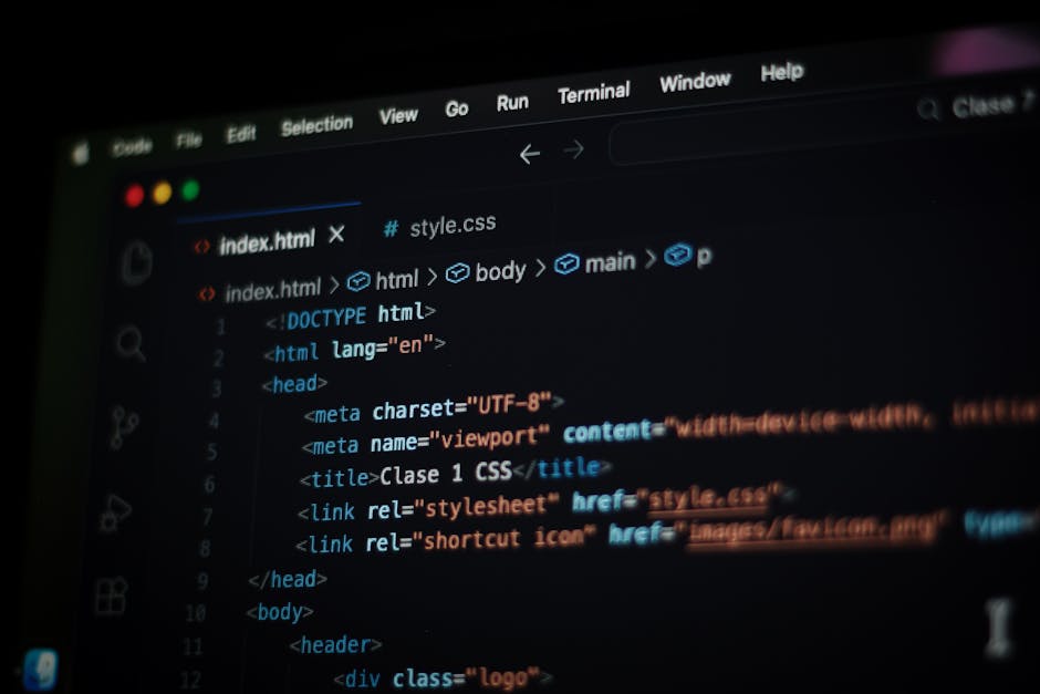 A person working on a laptop computer with a sleek, modern design, opening a code editing or development environment that displays lines of programming code in green, blue, and white text on a dark ba